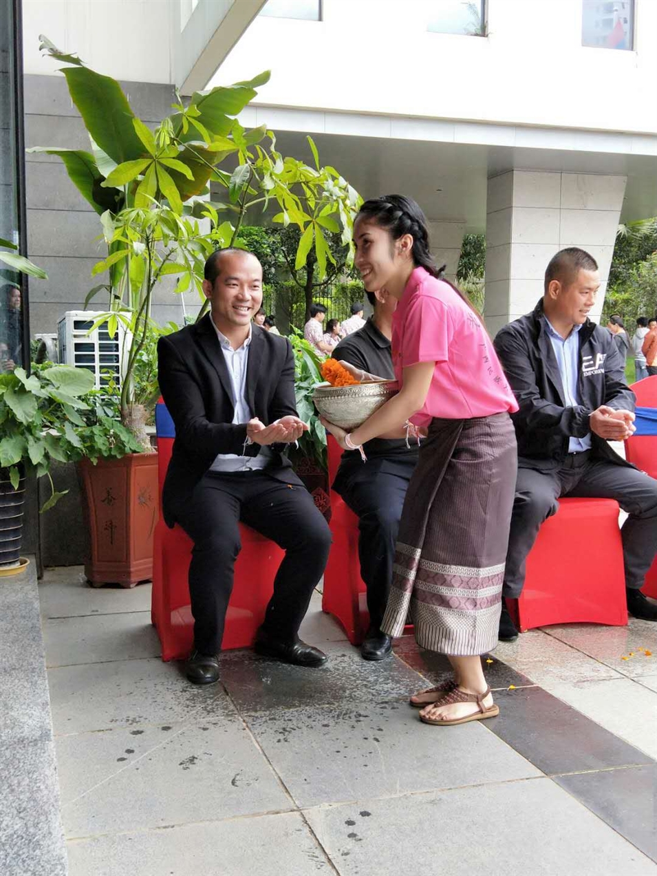 老撾駐廣西留學(xué)生代表將浸有花瓣的香水灑客人的手上，表示對(duì)嘉賓的美好祝福（圖一）
