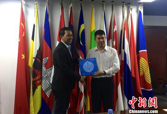 中國(guó)—東盟博覽會(huì)秘書處副秘書長(zhǎng)黃平西（右）與柬埔寨新聞部新聞與傳播總司副總司長(zhǎng)春占皮侖（左）互贈(zèng)禮物。