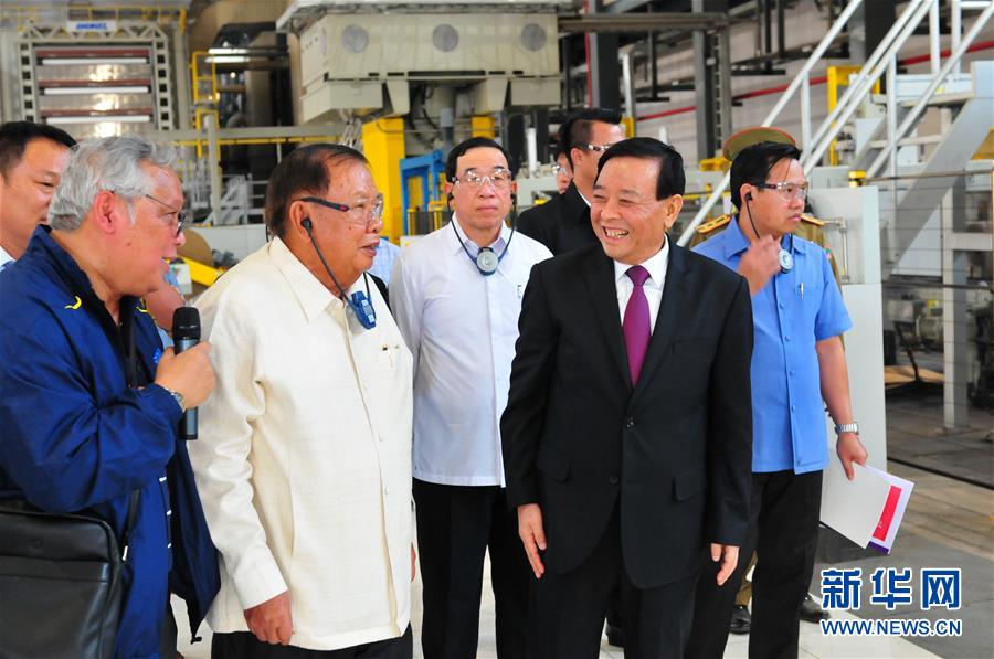 3月10日，在老撾沙灣拿吉省車邦縣，老撾人民革命黨中央總書記、國家主席本揚（左二）在山東太陽紙業(yè)股份有限公司董事長李洪信（右二）的陪同下視察公司。 新華社記者章建華攝